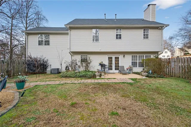 a view of house with yard and sitting area