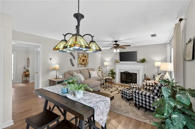 a living room with furniture a fireplace and a chandelier