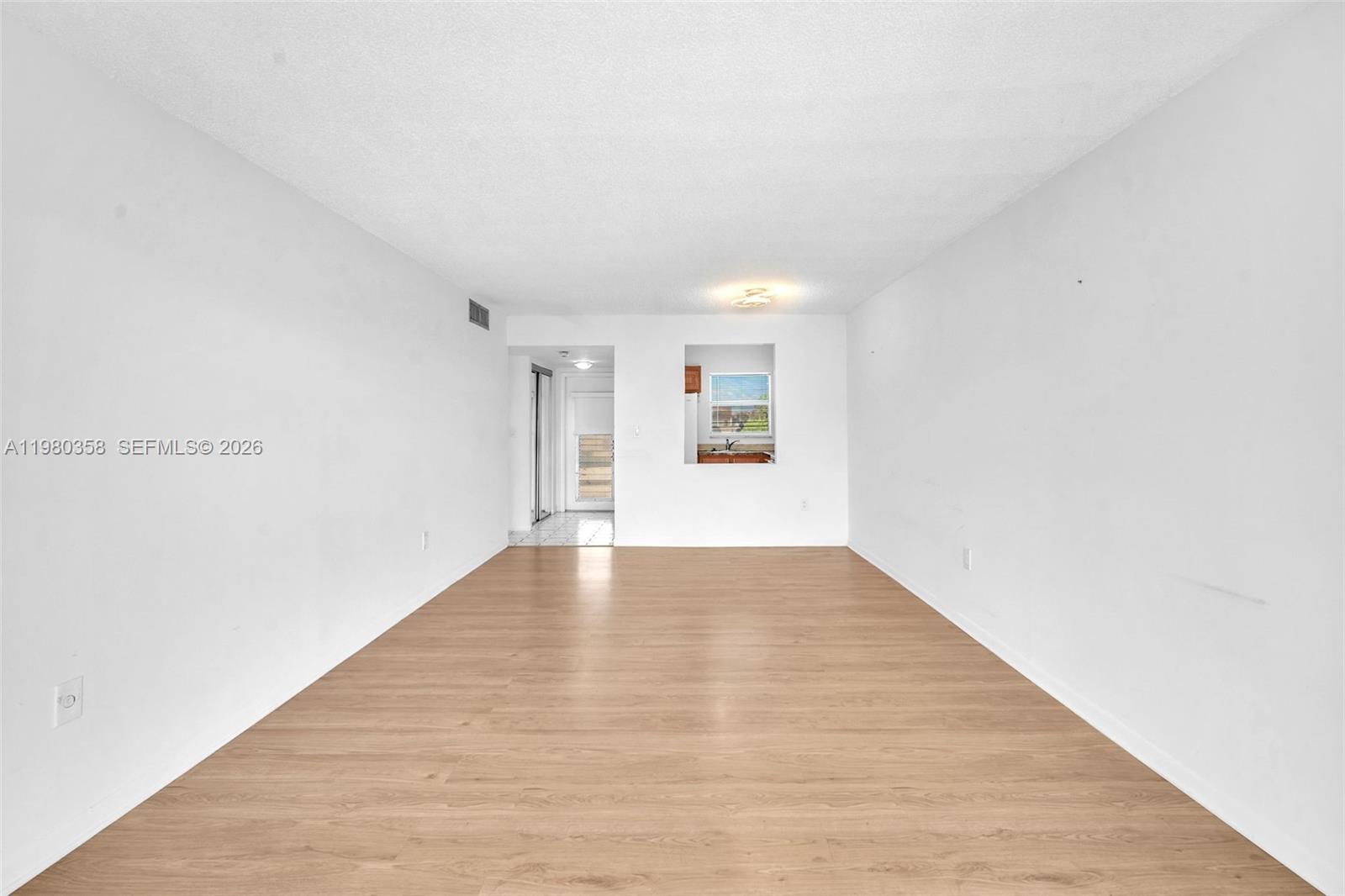 2720 North Pine Island Road, Unit 306 Sunrise, FL 33322 - Photo 17 of 23 a view of an empty room with wooden floor and a window