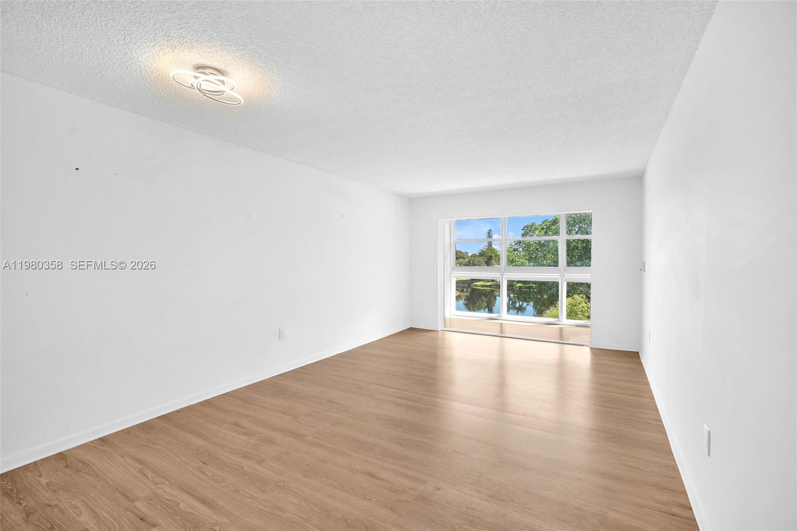 2720 North Pine Island Road, Unit 306 Sunrise, FL 33322 - Photo 23 of 23 an empty room with wooden floor and windows