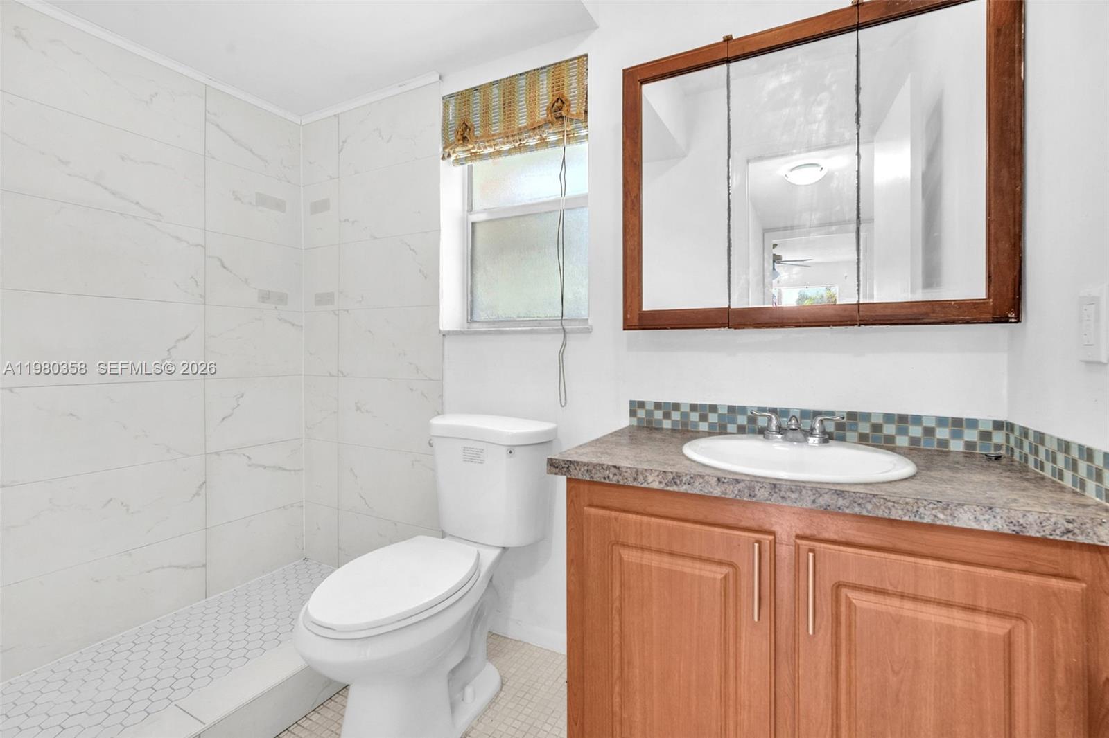 2720 North Pine Island Road, Unit 306 Sunrise, FL 33322 - Photo 4 of 23 a bathroom with a granite countertop sink toilet and mirror