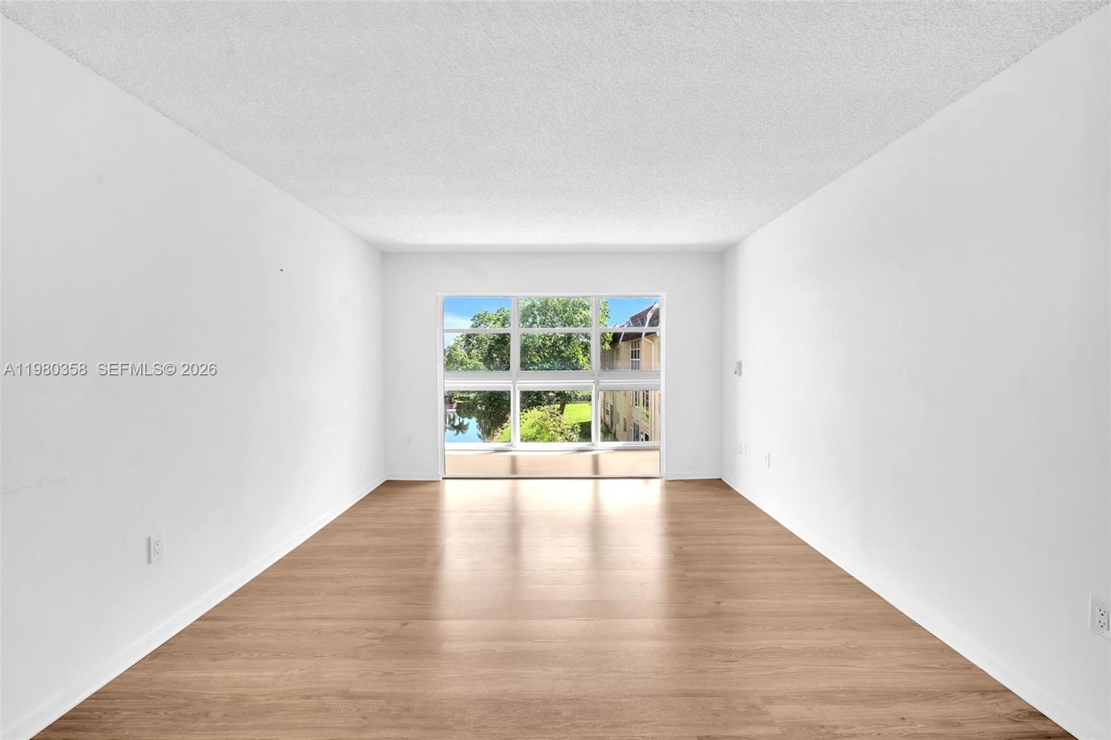 2720 North Pine Island Road, Unit 306 Sunrise, FL 33322 - Photo 6 of 23 an empty room with wooden floor and windows