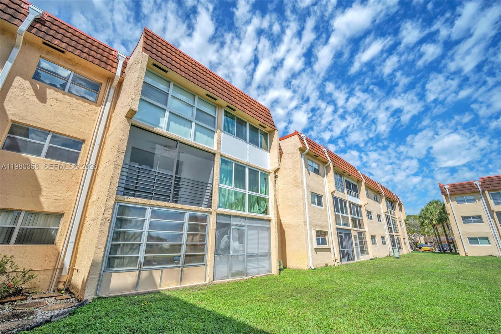 2720 North Pine Island Road, Unit 306 Sunrise, FL 33322 - Photo 10 of 23 a front view of a building with a garden