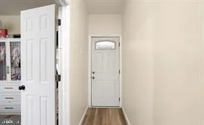 a view of a hallway with wooden floor and entryway