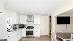 a kitchen with stainless steel appliances white cabinets a sink and a stove