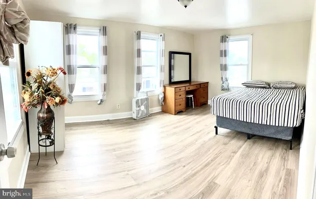 a spacious bedroom with a bed a couch and a window