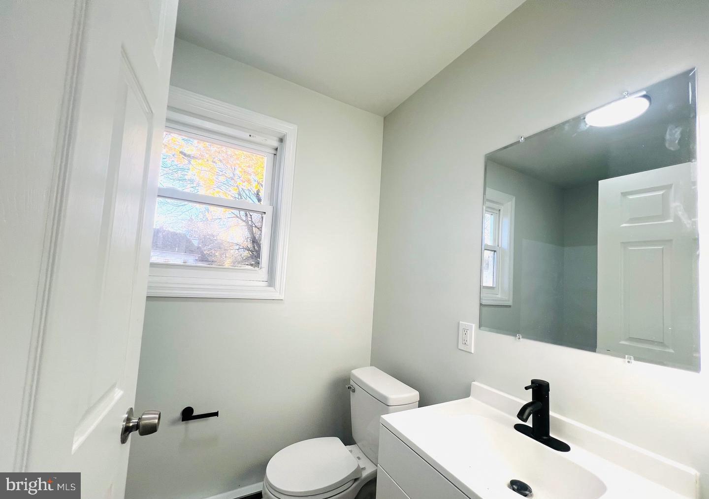 401 Blue Bell Road, Unit B Williamstown, NJ 08094 - Photo 9 of 11 a bathroom with a sink mirror and toilet