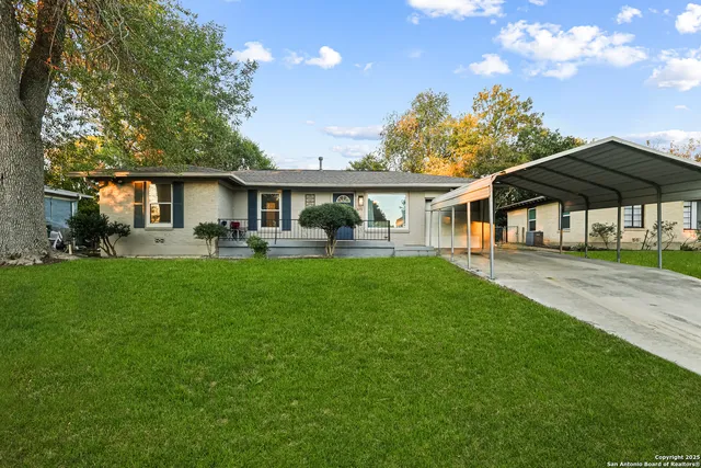 a front view of a house with garden and trees