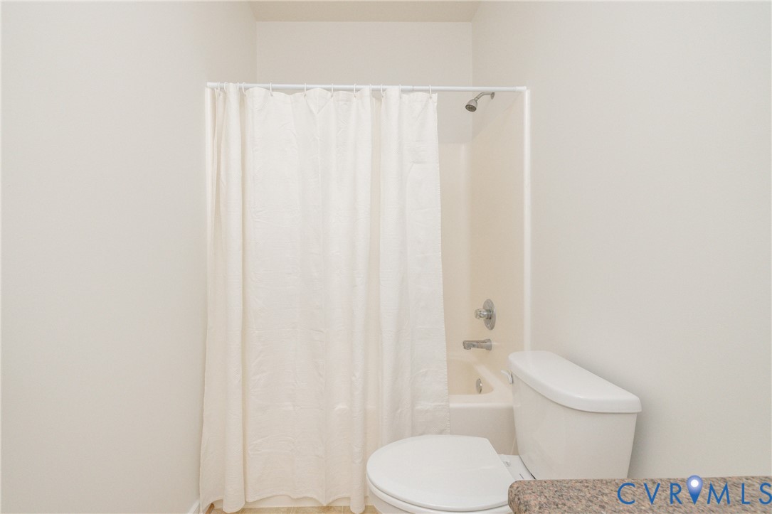 15618 Rowlett Road Chesterfield, VA 23838 - Photo 16 of 29 a white toilet next to a shower curtain