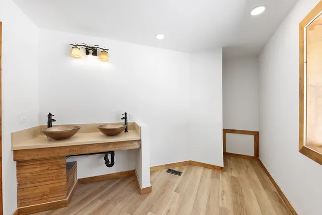 a bathroom with a sink double vanity granite tub shower and a mirror