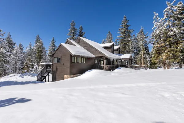 a front view of a house with a yard covered with snow