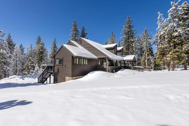 a front view of a house with a yard covered with snow