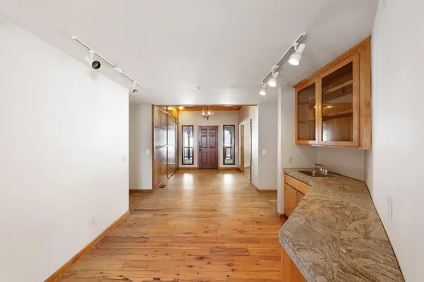 a view of wooden floor chandelier and window in a room