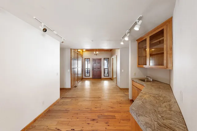a view of wooden floor chandelier and window in a room