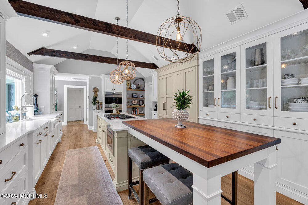921 Lovett Road Colts Neck, NJ 07722 - Photo 12 of 55 a large kitchen with kitchen island a stove a sink a dining table and chairs