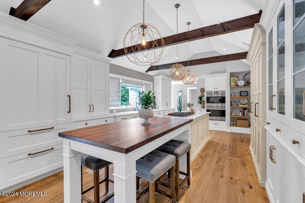 921 Lovett Road Colts Neck, NJ 07722 - Photo 14 of 55 a kitchen with a table chairs and a wooden floor