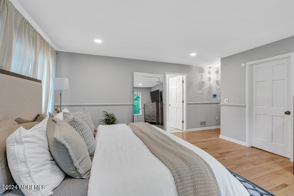 921 Lovett Road Colts Neck, NJ 07722 - Photo 29 of 55 a spacious bedroom with a bed and a large mirror