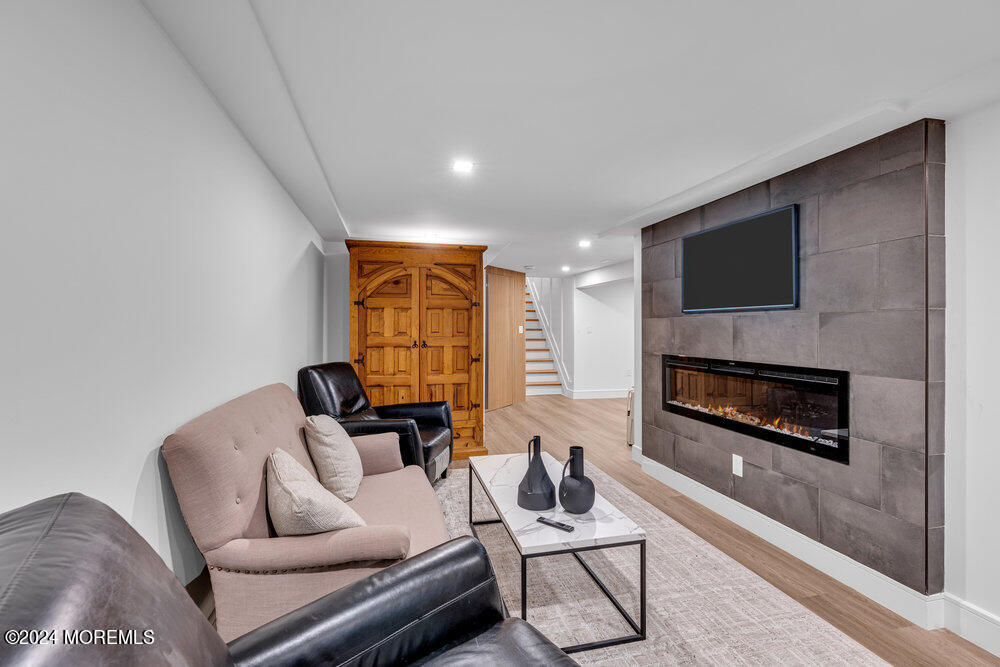 921 Lovett Road Colts Neck, NJ 07722 - Photo 41 of 55 a living room with furniture a flat screen tv and a fireplace