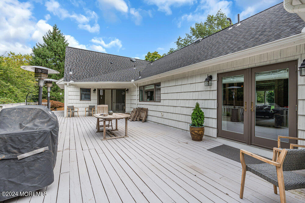 921 Lovett Road Colts Neck, NJ 07722 - Photo 50 of 55 a view of a patio with table and chairs potted plants with wooden floor and fence