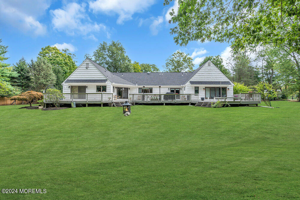 921 Lovett Road Colts Neck, NJ 07722 - Photo 54 of 55 a front view of a house with a yard table and chairs