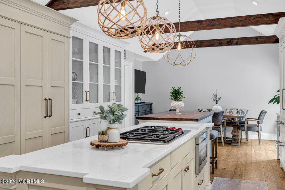 921 Lovett Road Colts Neck, NJ 07722 - Photo 9 of 55 a dining room with wooden floor a chandelier a wooden table and chairs