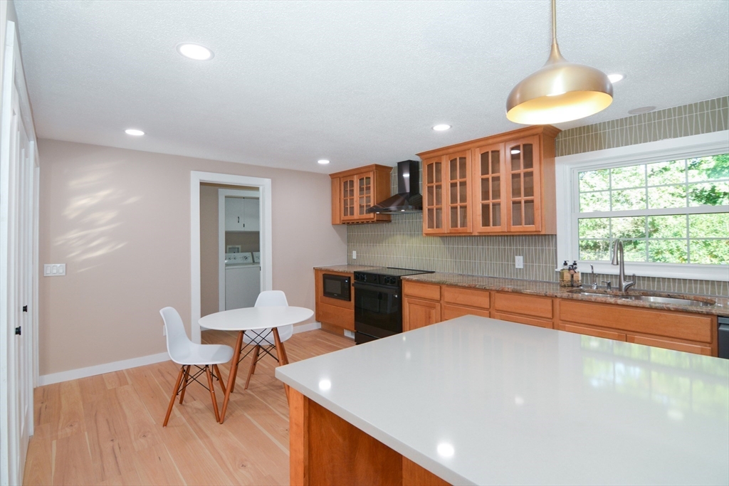 157 Captain Road Longmeadow, MA 01106 - Photo 11 of 41 a kitchen with stainless steel appliances granite countertop a table chairs sink and window