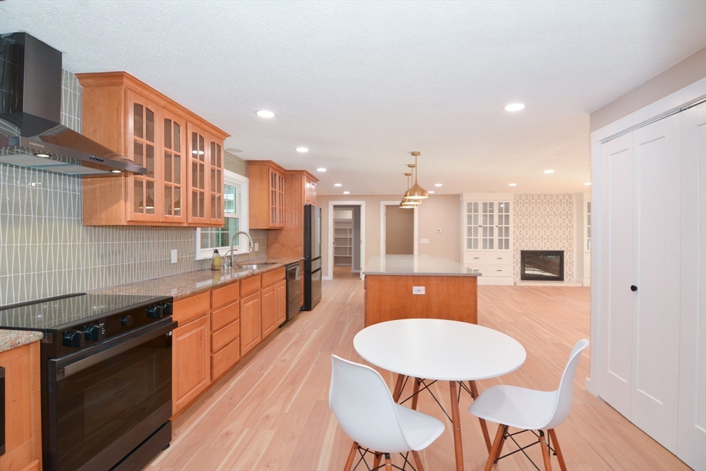 157 Captain Road Longmeadow, MA 01106 - Photo 14 of 41 a kitchen with stainless steel appliances granite countertop a kitchen island hardwood floor sink stove dining table and chairs