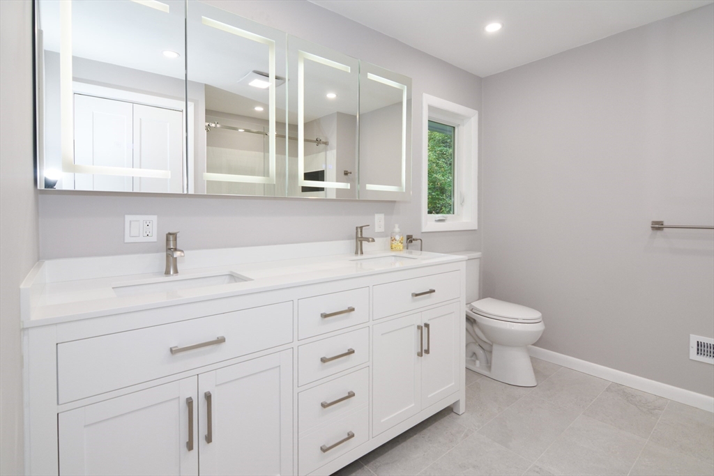 157 Captain Road Longmeadow, MA 01106 - Photo 20 of 41 a bathroom with a toilet a sink a mirror and vanity
