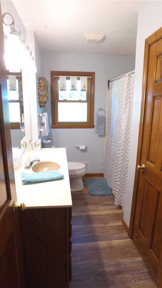 5701 Tipple Road Rockford, IL 61102 - Photo 18 of 21 a bathroom with a sink a mirror and a bathtub