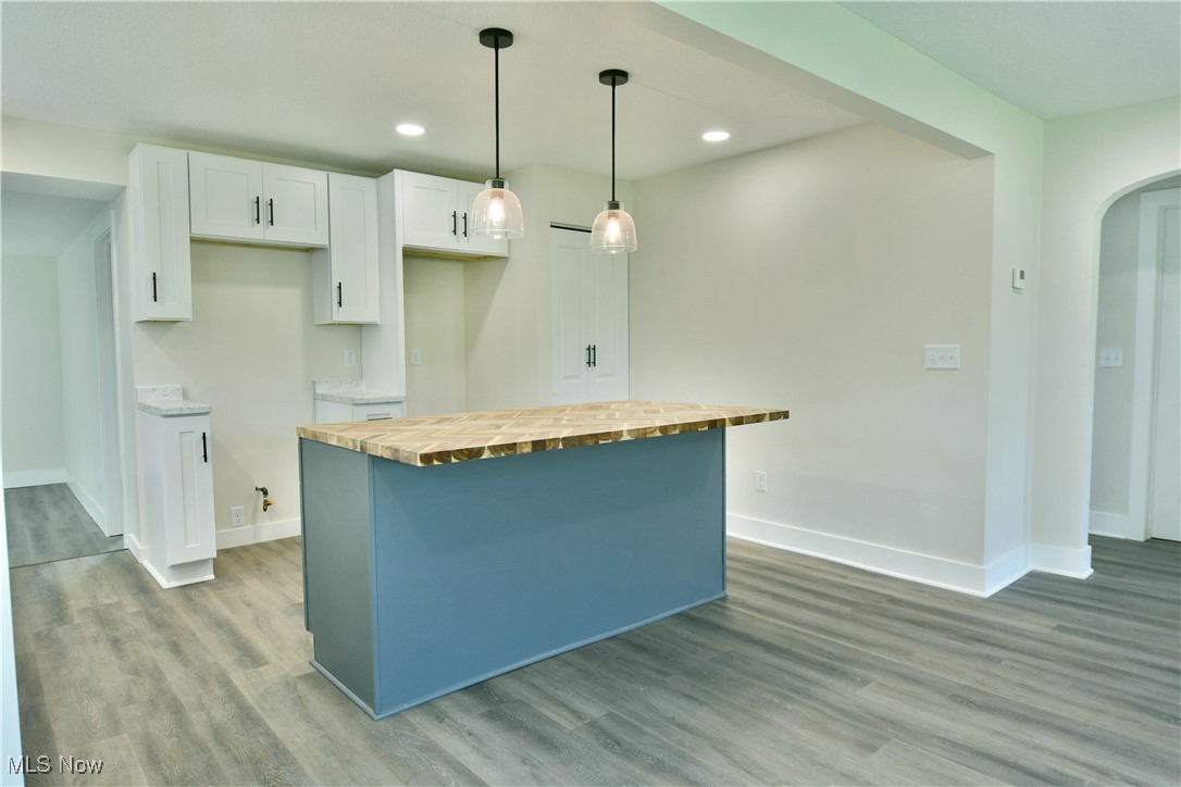 2096 Stillwagon Road Southeast Warren, OH 44484 - Photo 8 of 50 Kitchen featuring wooden counters, baseboards, a center island, light wood-type flooring, and white cabinets