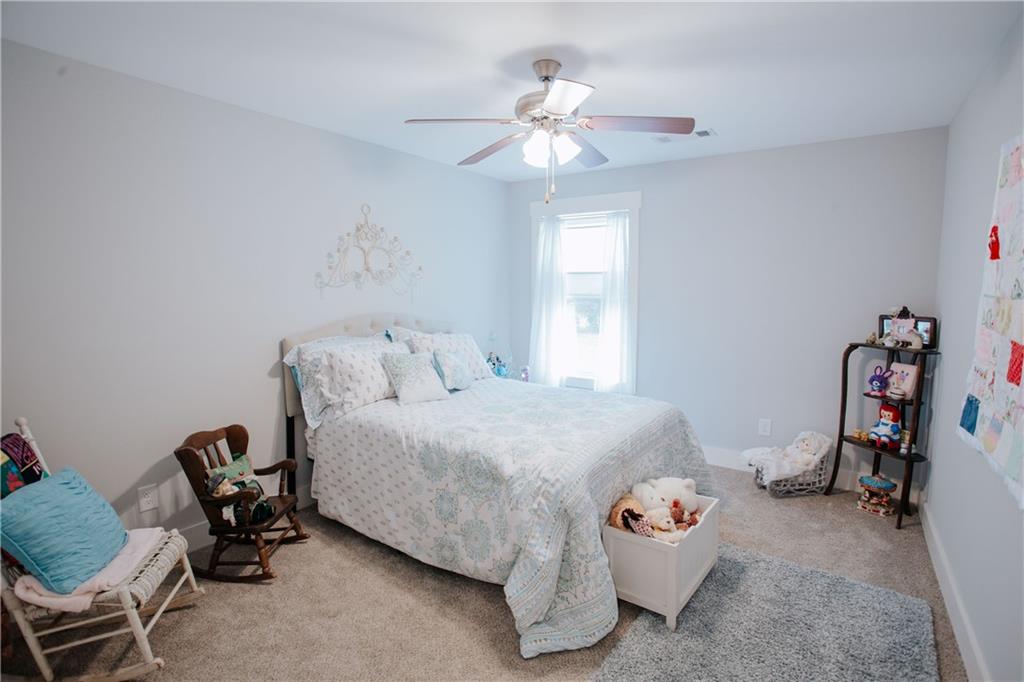 3221 Hollonville Road Williamson, GA 30292 - Photo 30 of 46 a bedroom with a bed and a chandelier