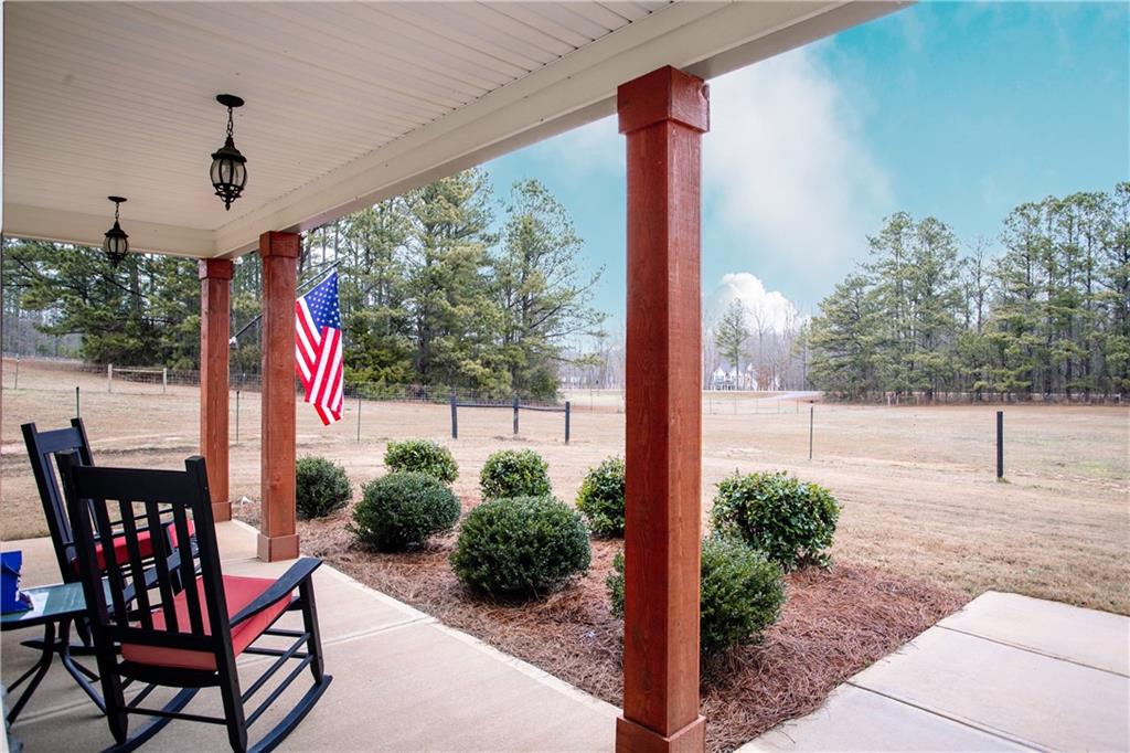 3221 Hollonville Road Williamson, GA 30292 - Photo 4 of 46 a porch area with potted plants and a table