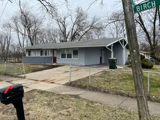 a front view of a house with a yard covered with snow