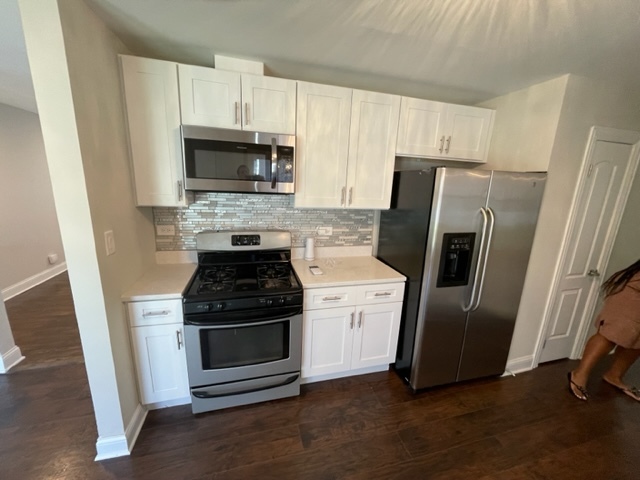 15303 Birch Road Markham, IL 60428 - Photo 6 of 12 a kitchen with a stove microwave and refrigerator