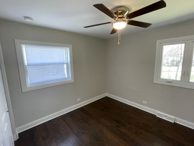 15303 Birch Road Markham, IL 60428 - Photo 9 of 12 a view of an empty room with wooden floor and a window
