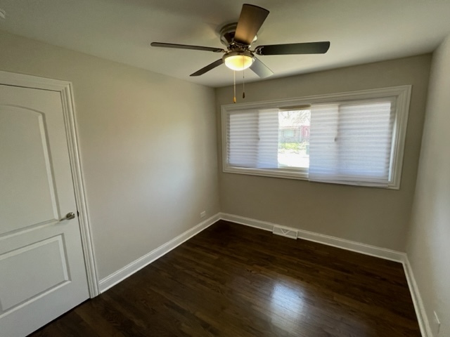 15303 Birch Road Markham, IL 60428 - Photo 10 of 12 a view of an empty room with wooden floor and a window