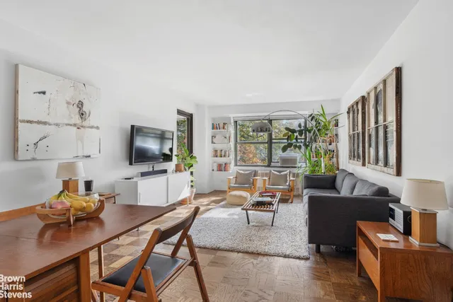 a living room with furniture a flat screen tv and a floor to ceiling window