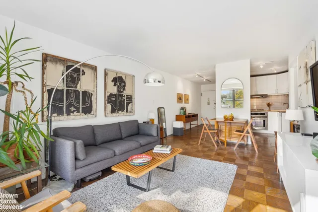 a living room with furniture a rug and a dining table with wooden floor