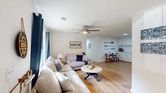 a living room with furniture a rug and white walls