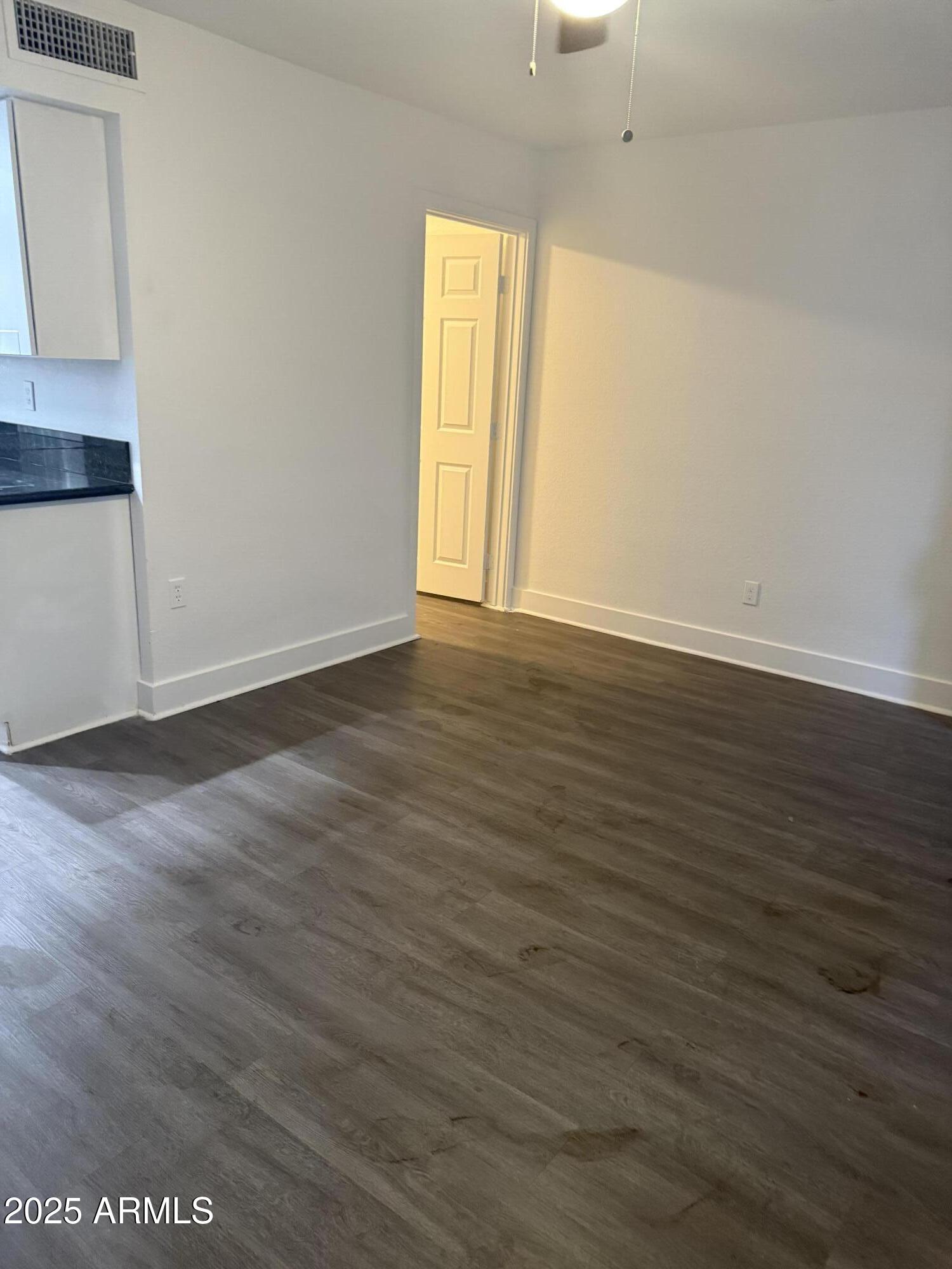 18202 Cave Creek Road, Unit 157 Phoenix, AZ 85032 - Photo 4 of 11 a view of an empty room with wooden floor and a window