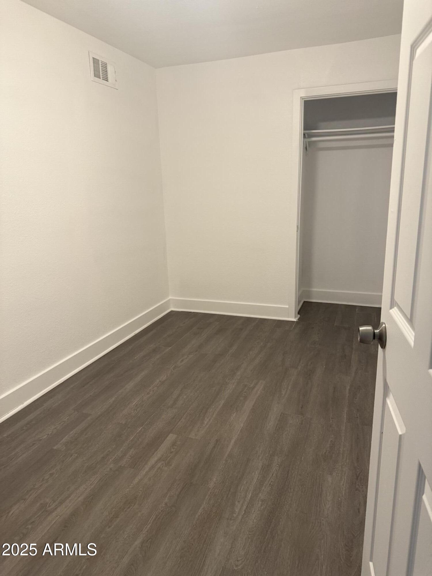 18202 Cave Creek Road, Unit 157 Phoenix, AZ 85032 - Photo 6 of 11 a view of an empty room with wooden floor and a window