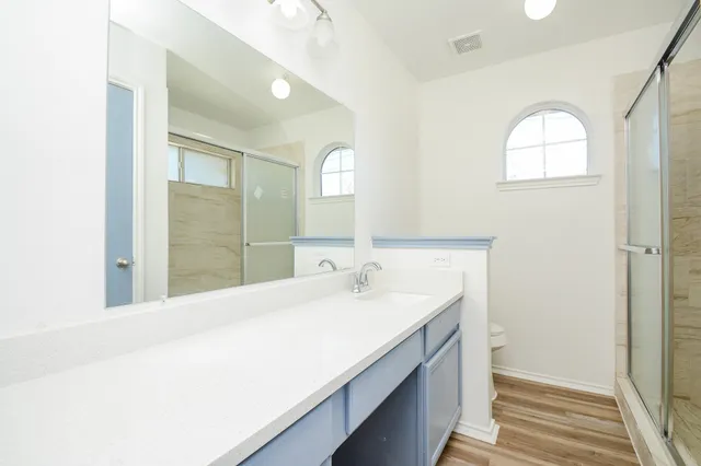 a bathroom with a granite countertop sink toilet and shower