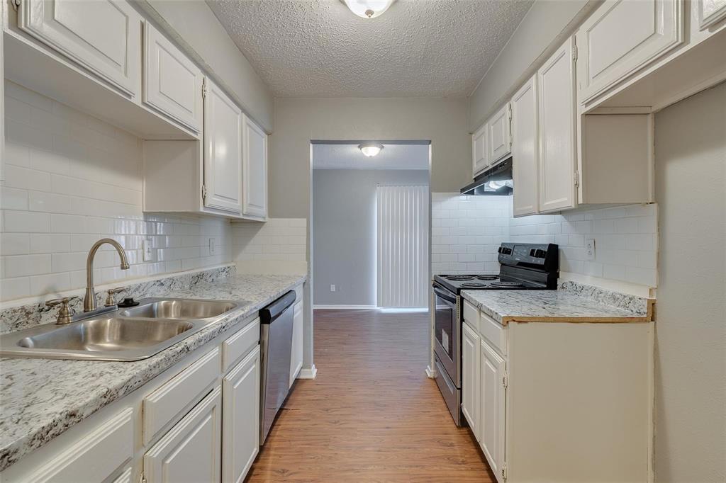 3959 North Garland Avenue, Unit 1 Garland, TX 75040 - Photo 5 of 11 a kitchen with stainless steel appliances granite countertop a sink stove and cabinets