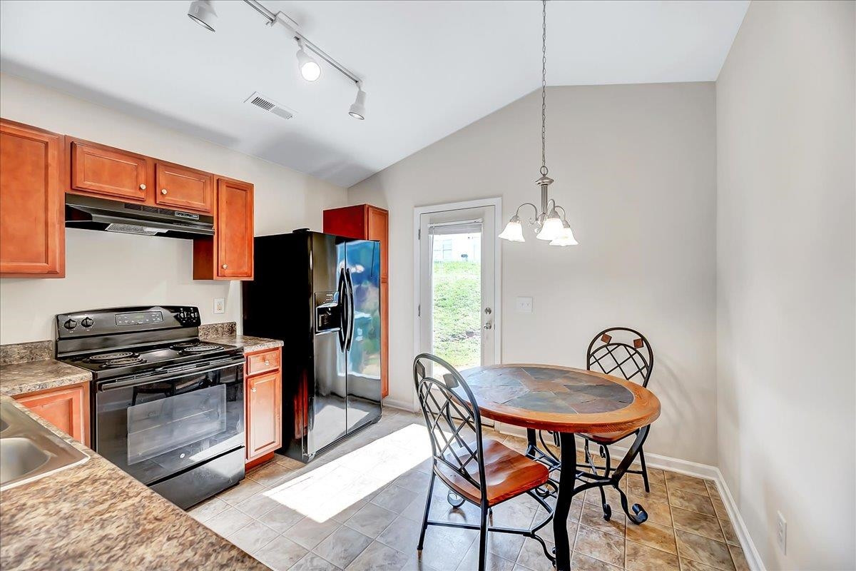 1621 Brownairs Lane Raleigh, NC 27610 - Photo 19 of 29 a kitchen with stainless steel appliances a stove a refrigerator and a dining table