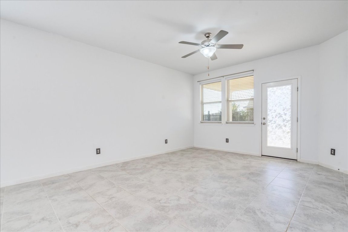101 Otella Street Georgetown, TX 78628 - Photo 11 of 33 an empty room with chandelier fan and windows