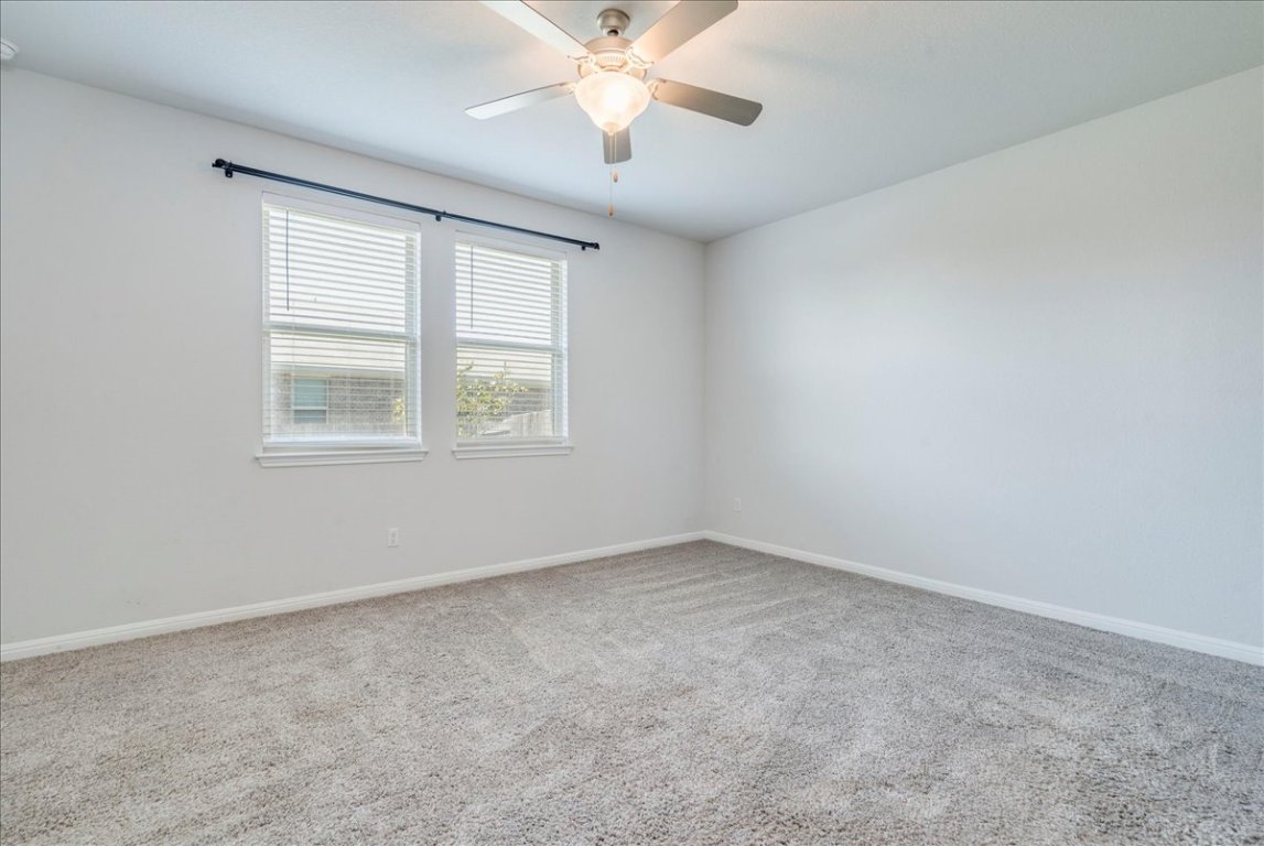 101 Otella Street Georgetown, TX 78628 - Photo 14 of 33 an empty room with a window and a ceiling fan