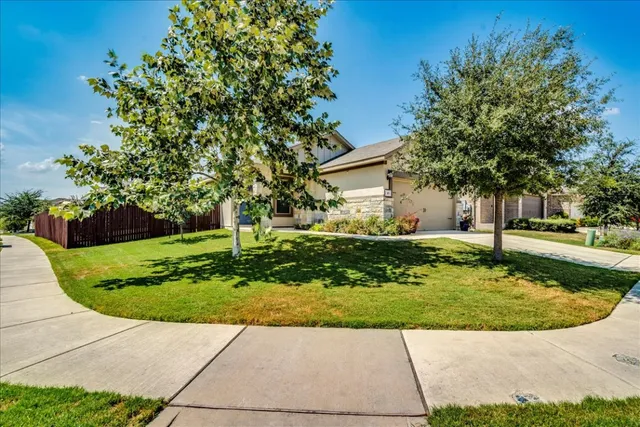 a view of a house with backyard and a tree