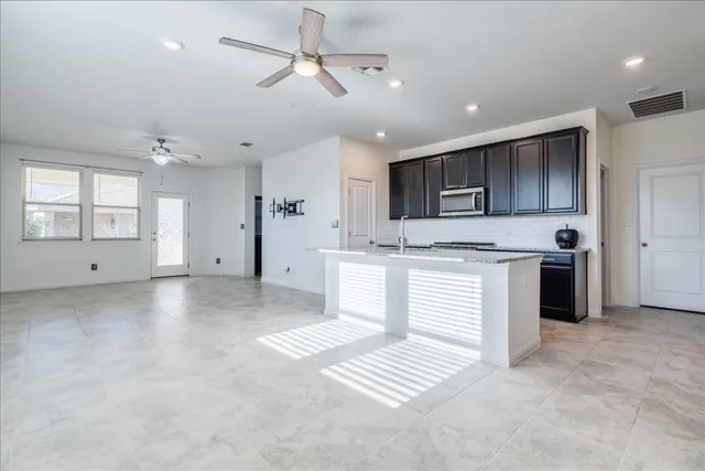 a view of kitchen with sink microwave and refrigerator