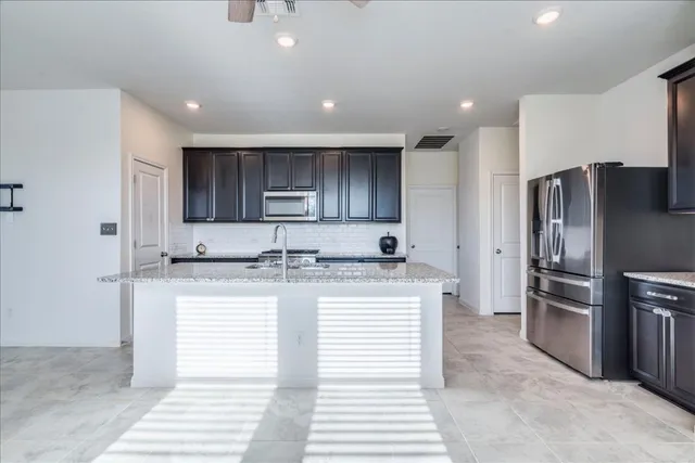 a kitchen with stainless steel appliances granite countertop a refrigerator and a sink