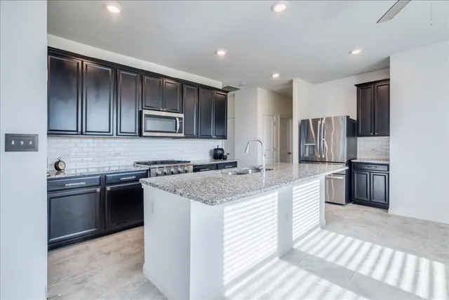 a kitchen with stainless steel appliances granite countertop a sink stove and refrigerator